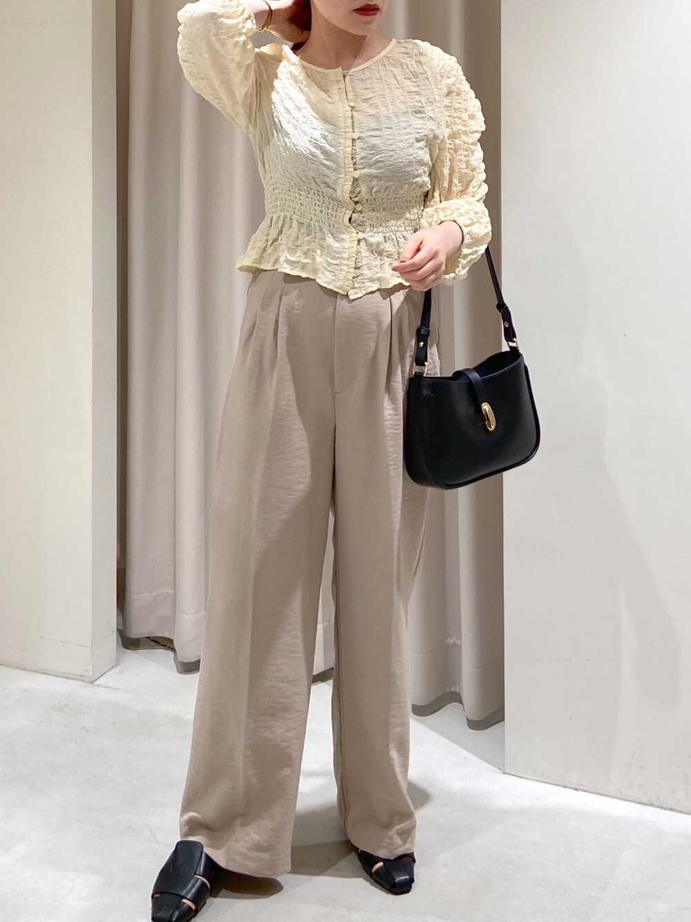 ベージュ系のテーラードジャケット、ホワイト系のスラックス、ホワイト系のカーディガン/ボレロを着用したレディースの春コーディネートの4枚目の写真