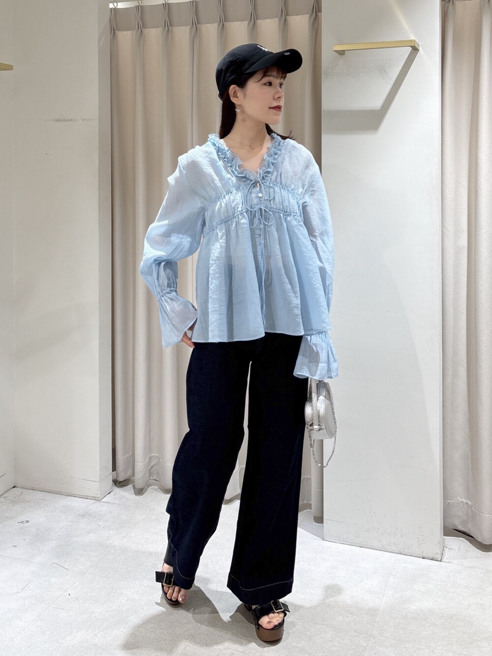 ブルー系のシャツ/ブラウス、シルバー系のショルダーバッグ、ブルー系のデニムパンツを着用したレディースの春コーディネートの6枚目の写真