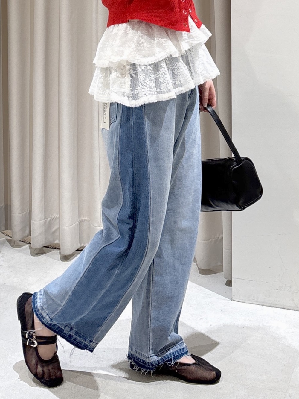 レッド系のニット/セーター、ホワイト系のシャツ/ブラウス、ブラック系のハンドバッグを着用したレディースの冬コーディネートの3枚目の写真