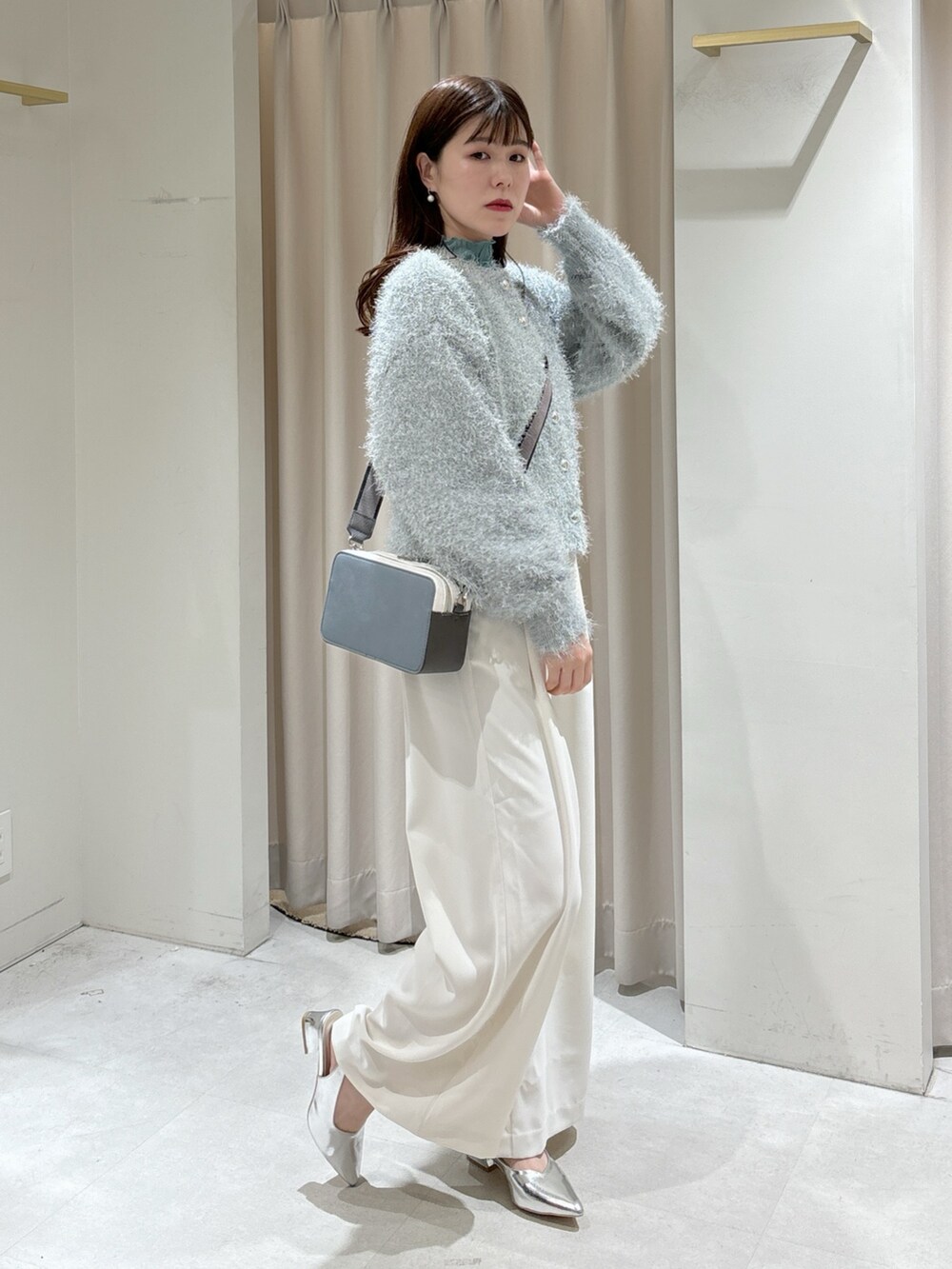 グリーン系のカーディガン/ボレロ、グリーン系のTシャツ/カットソー、ホワイト系のスラックスを着用したレディースの冬コーディネートの2枚目の写真