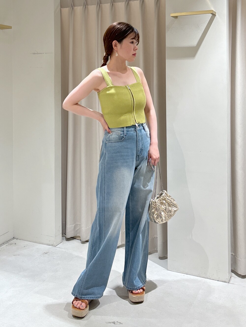 グリーン系のニット/セーター、ブルー系のデニムパンツ、ホワイト系のシャツ/ブラウスを着用したレディースの夏コーディネートの7枚目の写真