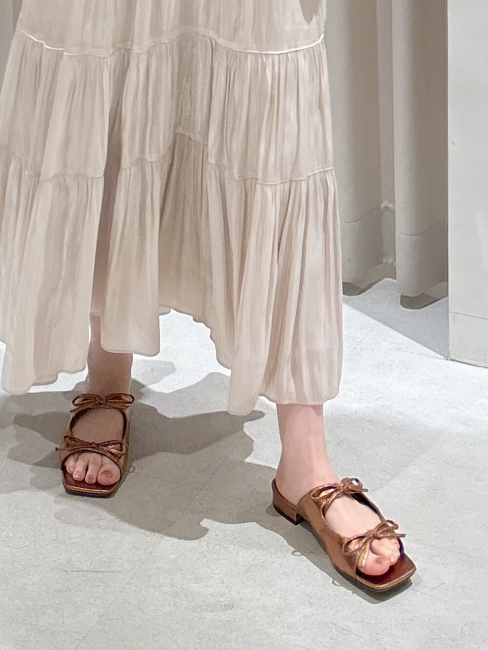 ホワイト系のニット/セーター、ベージュ系のショルダーバッグ、ホワイト系のスカートを着用したレディースの春コーディネートの5枚目の写真