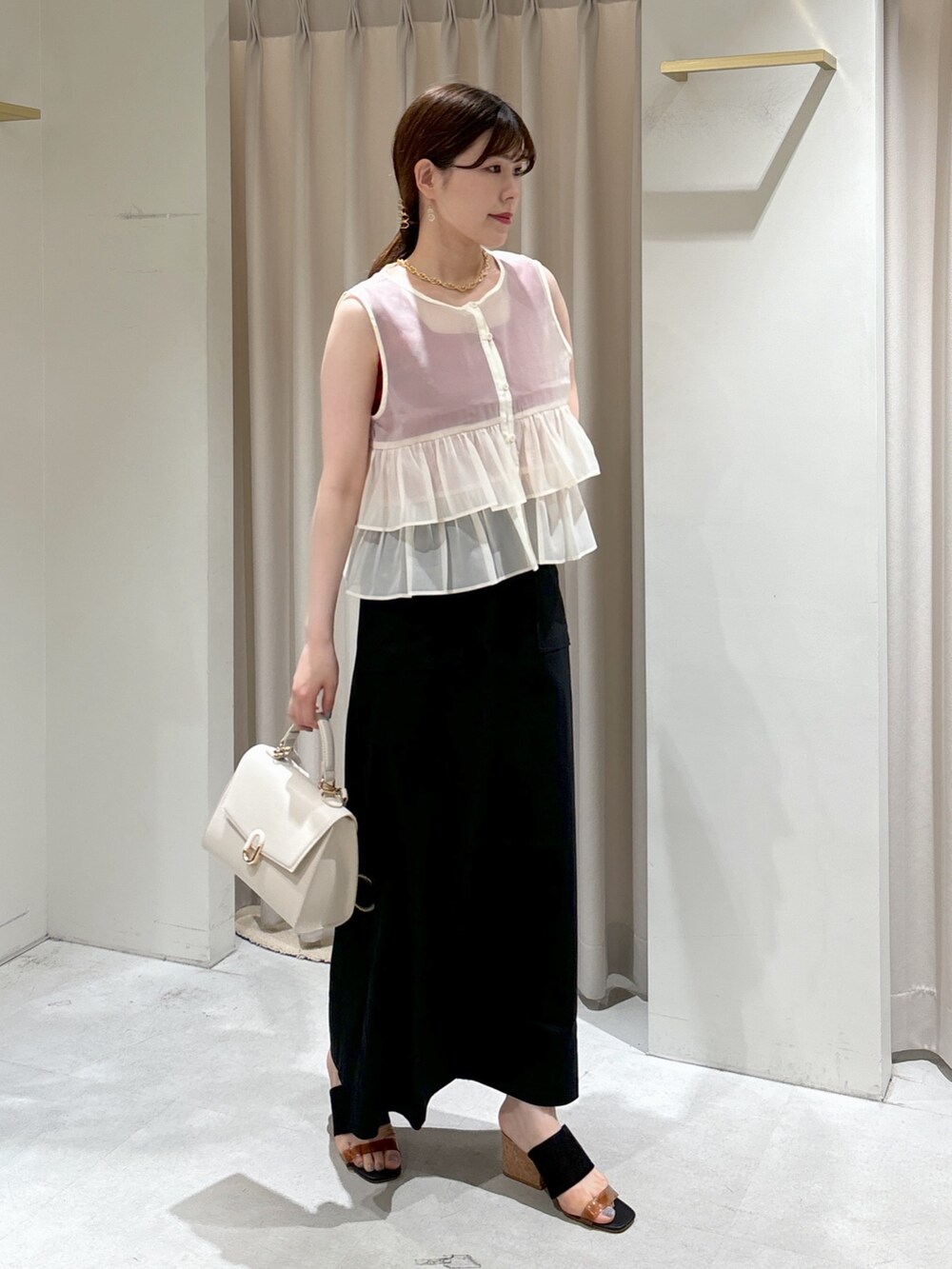 ホワイト系のシャツ/ブラウス、レッド系のタンクトップ、ホワイト系のショルダーバッグを着用したレディースの夏コーディネートの2枚目の写真