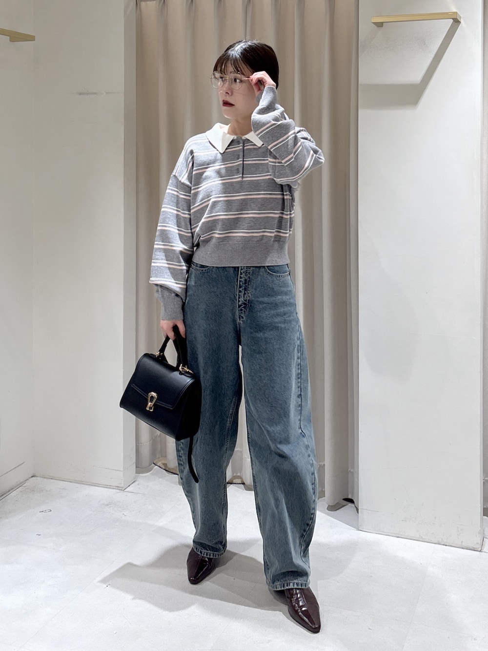 グレー系のニット/セーター、ブラック系のトートバッグ、ブラウン系のパンプスを着用したレディースの冬コーディネートの2枚目の写真