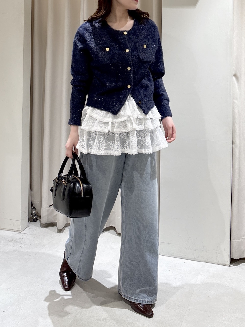 ブルー系のニット/セーター、ホワイト系のシャツ/ブラウス、ブルー系のデニムパンツを着用したレディースの冬コーディネートの3枚目の写真