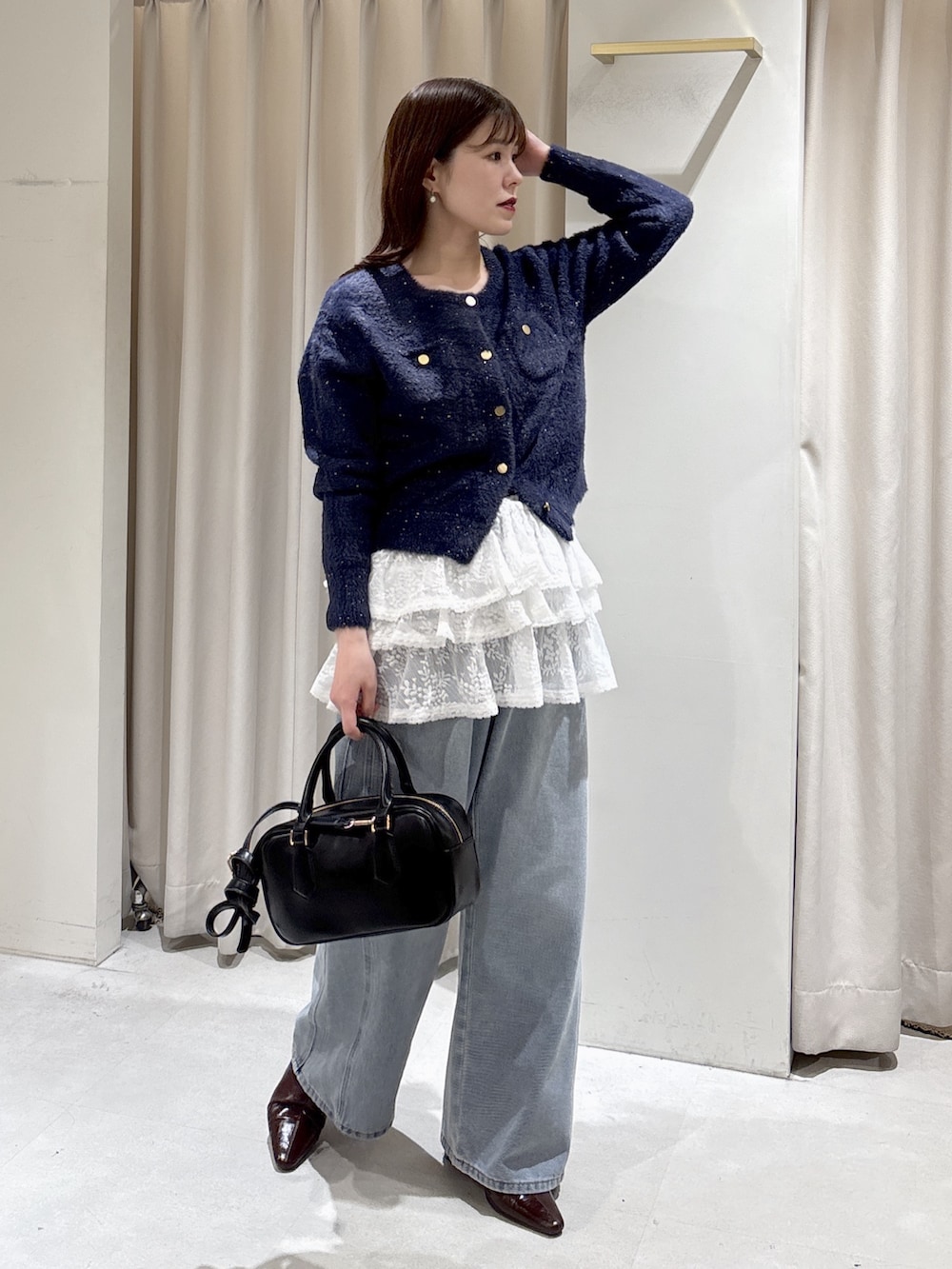 ブルー系のニット/セーター、ホワイト系のシャツ/ブラウス、ブルー系のデニムパンツを着用したレディースの冬コーディネートの2枚目の写真