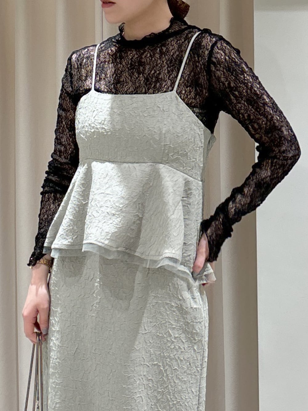 グリーン系のワンピース、ブラック系のTシャツ/カットソー、ベージュ系のショルダーバッグを着用したレディースの冬コーディネートの5枚目の写真