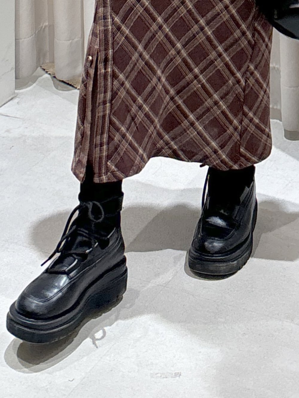 ブラウン系のワンピース、ホワイト系のカーディガン/ボレロ、ブラック系のTシャツ/カットソーを着用したレディースの冬コーディネートの7枚目の写真