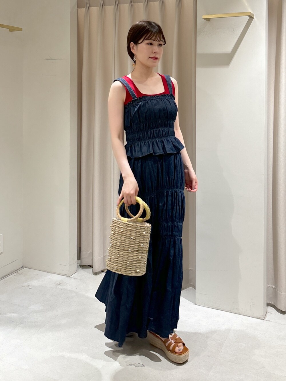 ブルー系のワンピース、レッド系のタンクトップ、イエロー系のかごバッグを着用したレディースの夏コーディネートの5枚目の写真