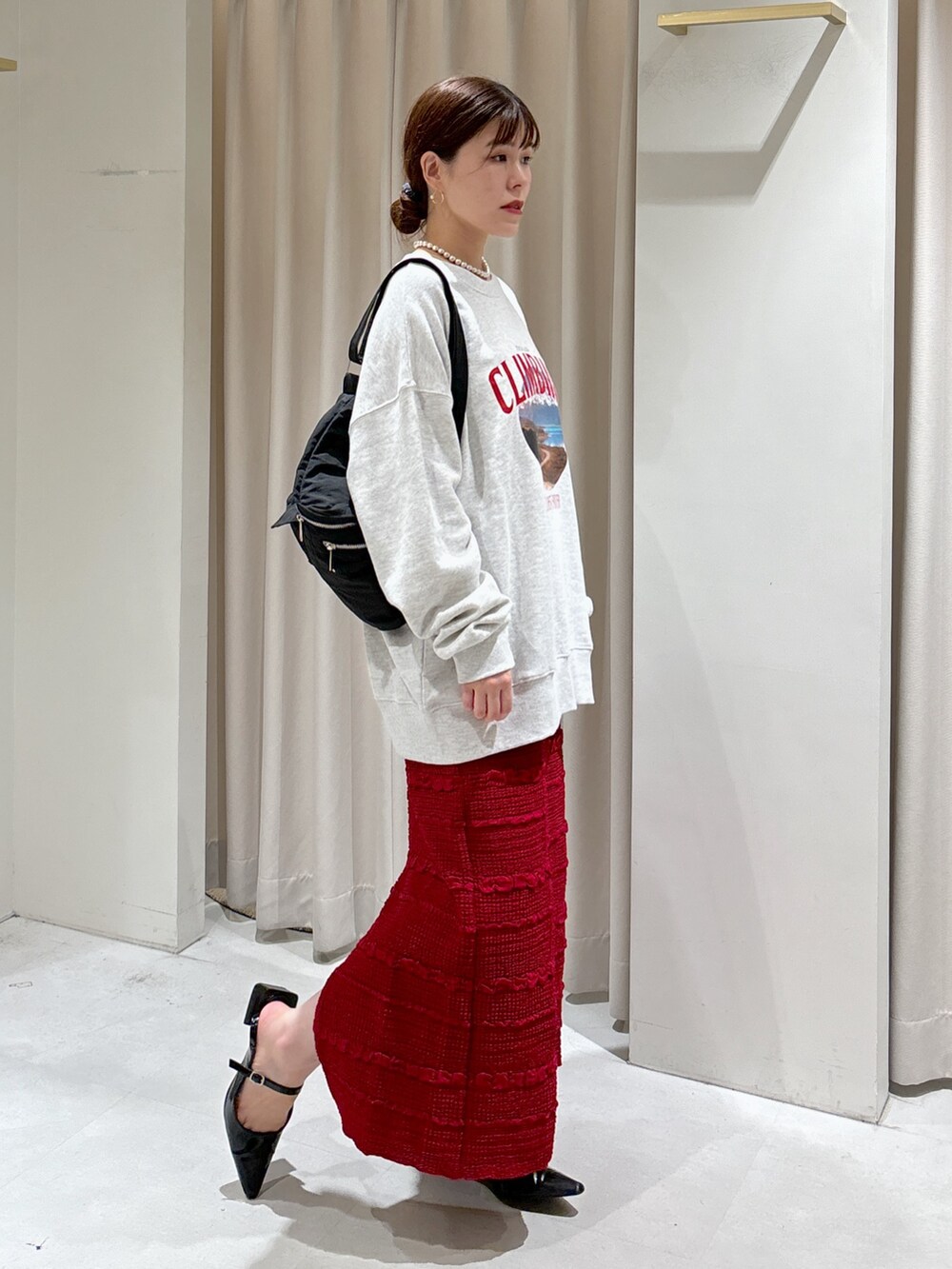 ホワイト系のスウェット、レッド系のスカート、ブラック系のパンプスを着用したレディースの秋コーディネートの5枚目の写真