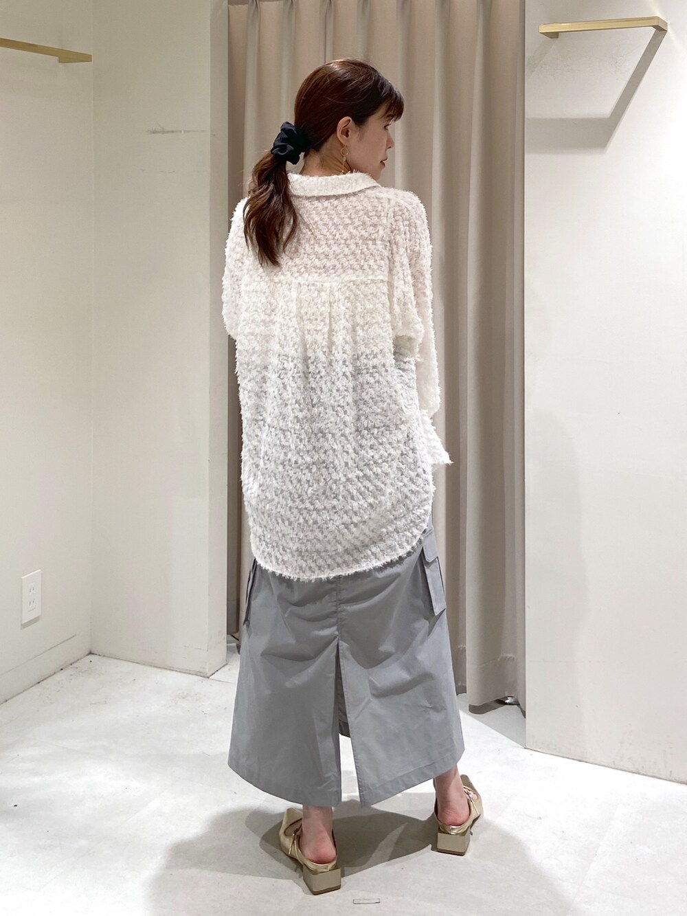 ブラック系のショルダーバッグ、ゴールド系のパンプス、ホワイト系のシャツ/ブラウスを着用したレディースの冬コーディネートの3枚目の写真