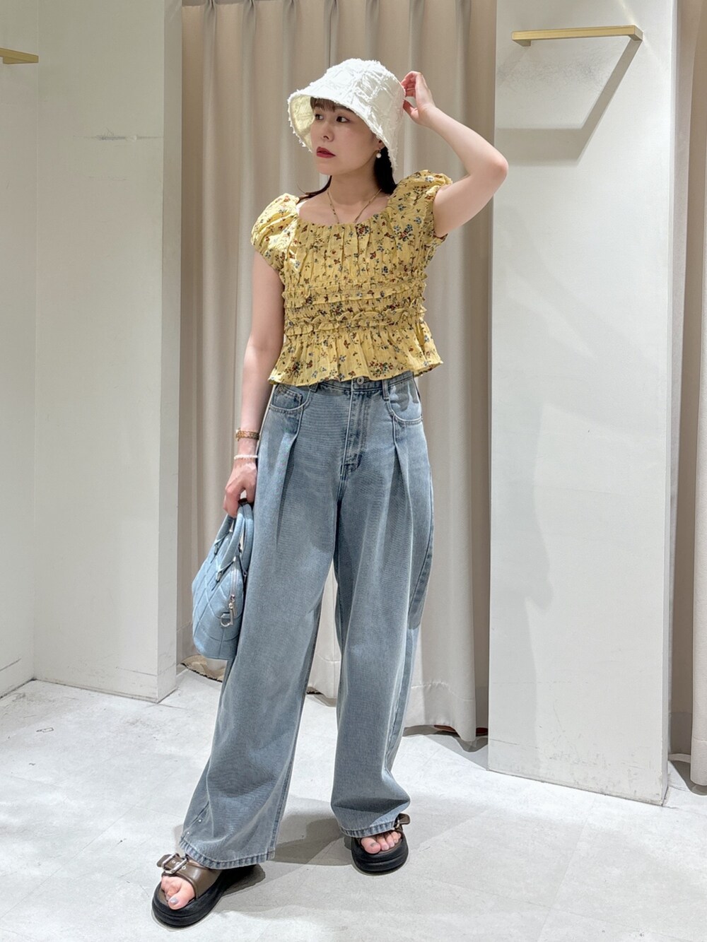 イエロー系のシャツ/ブラウス、ブルー系のトートバッグ、ブルー系のデニムパンツを着用したレディースの夏コーディネートの6枚目の写真