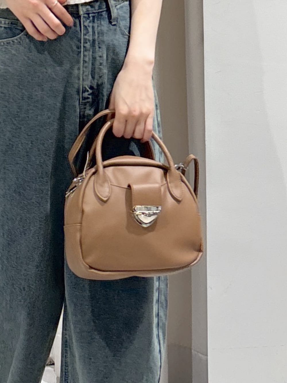 ホワイト系のシャツ/ブラウス、ブラウン系のハンドバッグ、ブルー系のデニムパンツを着用したレディースの夏コーディネートの5枚目の写真