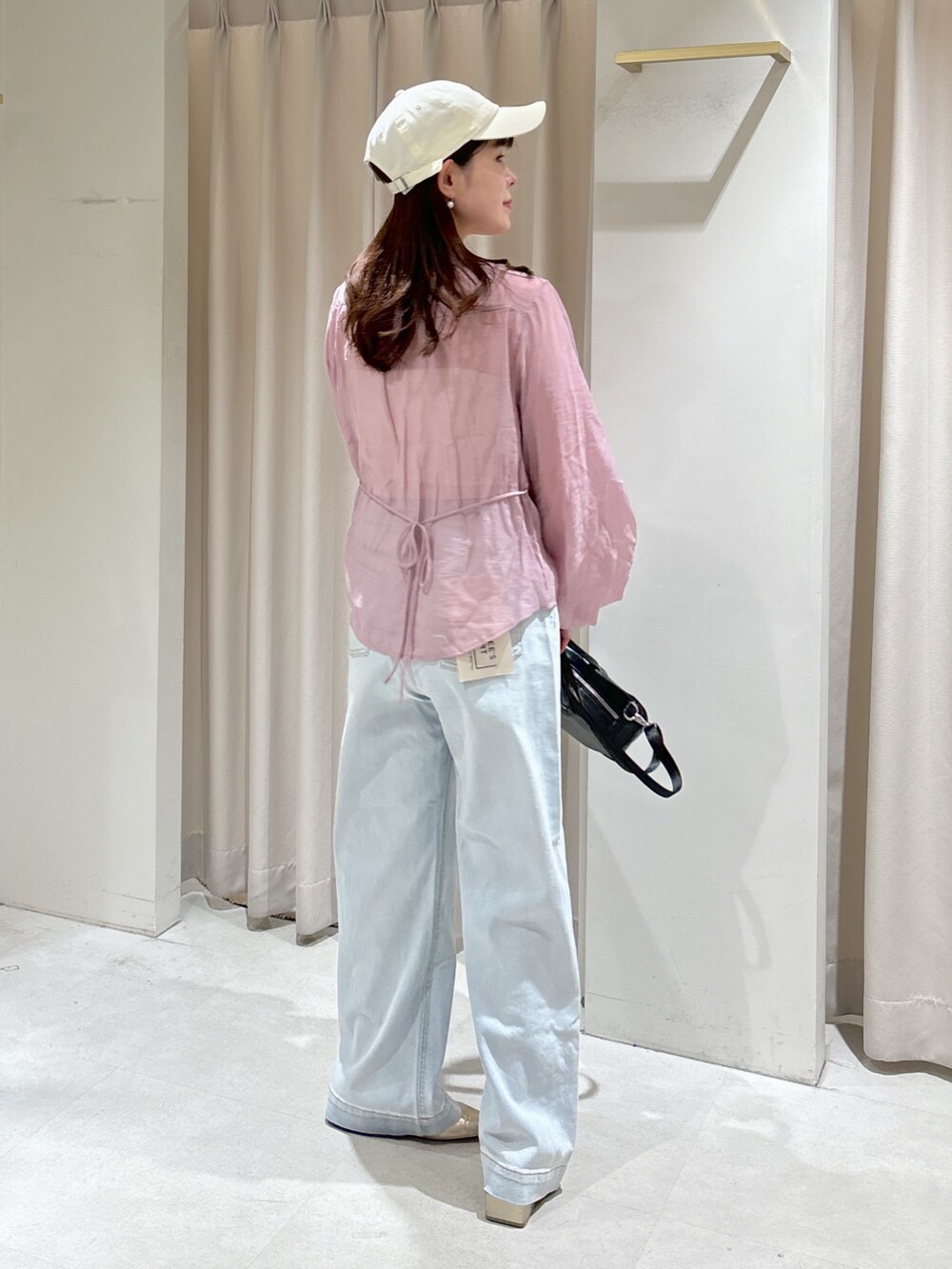 ピンク系のシャツ/ブラウス、ホワイト系のキャミソール、ブラック系のトートバッグを着用したレディースの春コーディネートの3枚目の写真