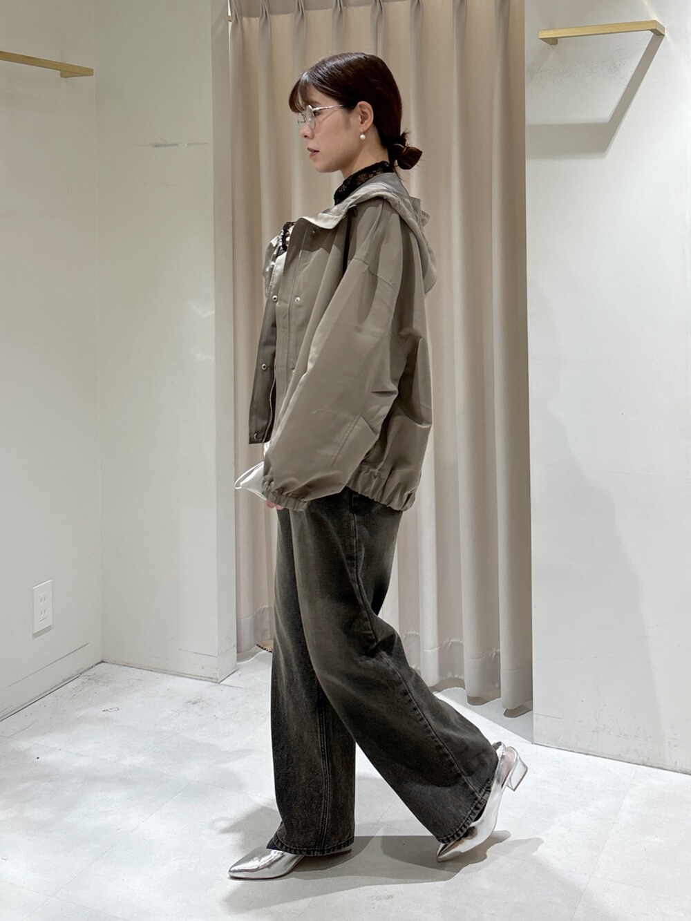 グリーン系のマウンテンパーカー、ブラック系のTシャツ/カットソー、ホワイト系のキャミソールを着用したレディースの冬コーディネートの3枚目の写真