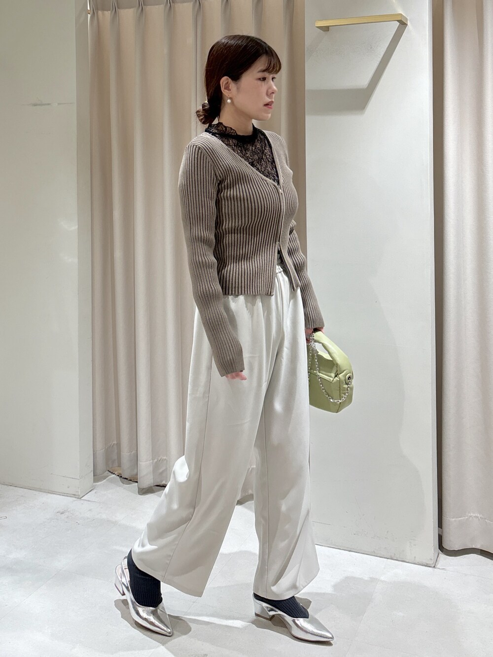 グリーン系のニット/セーター、ブラック系のTシャツ/カットソー、ホワイト系のキャミソールを着用したレディースの冬コーディネートの2枚目の写真