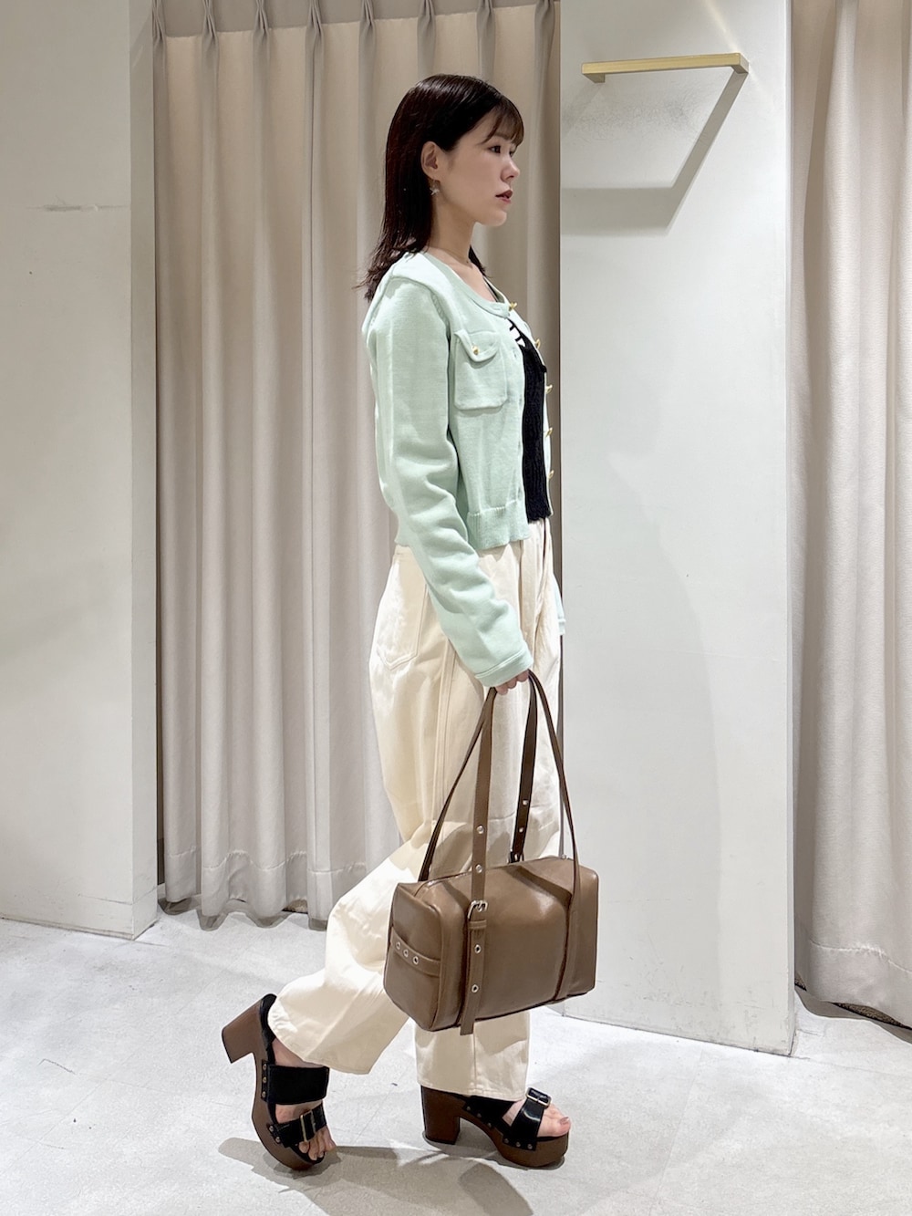 ブラック系のニット/セーター、グリーン系のニット/セーター、ホワイト系のニット/セーターを着用したレディースの春コーディネートの2枚目の写真