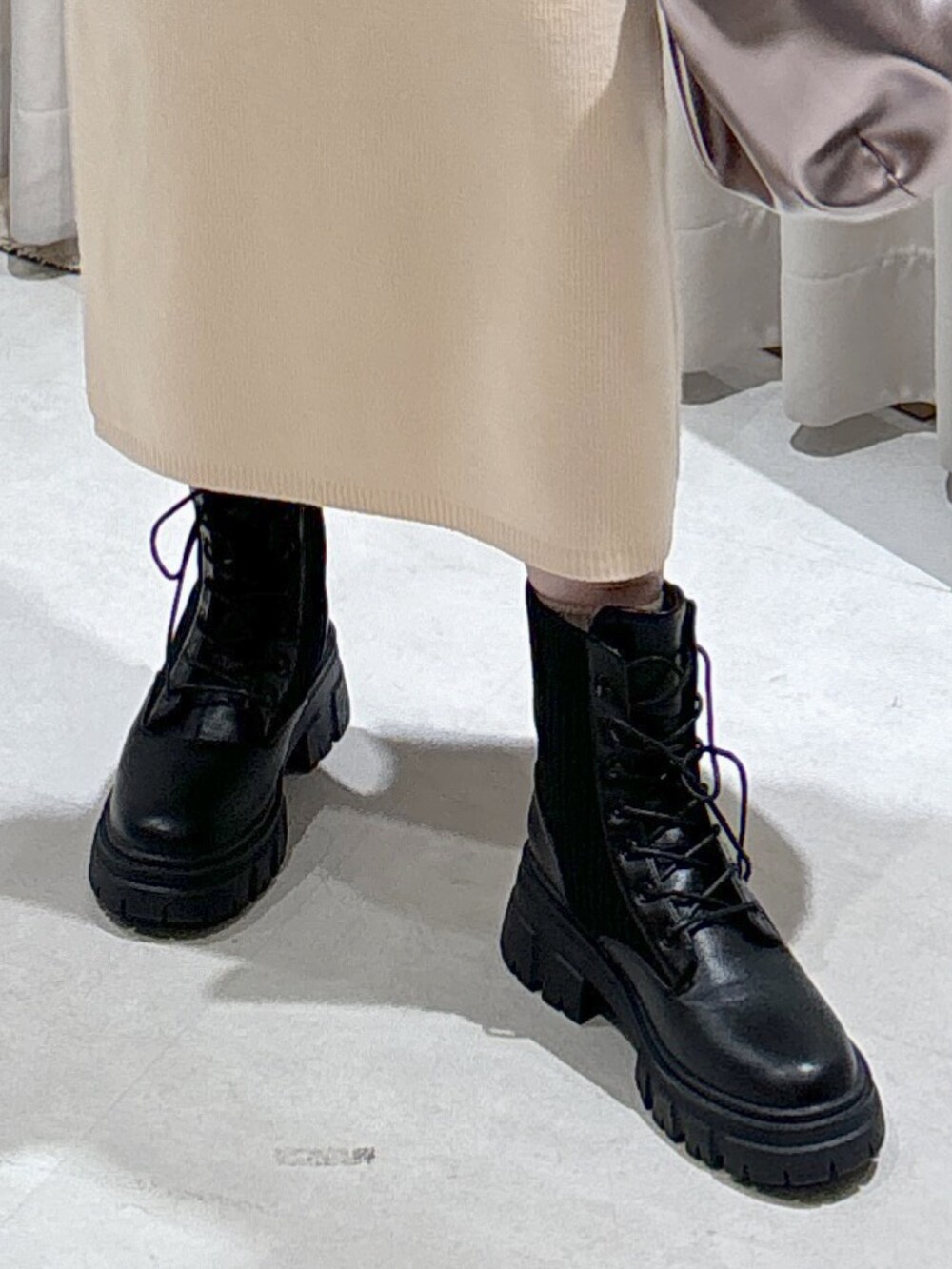 ホワイト系のワンピース、シルバー系のハンドバッグ、ブラック系のブーツを着用したレディースの秋コーディネートの6枚目の写真