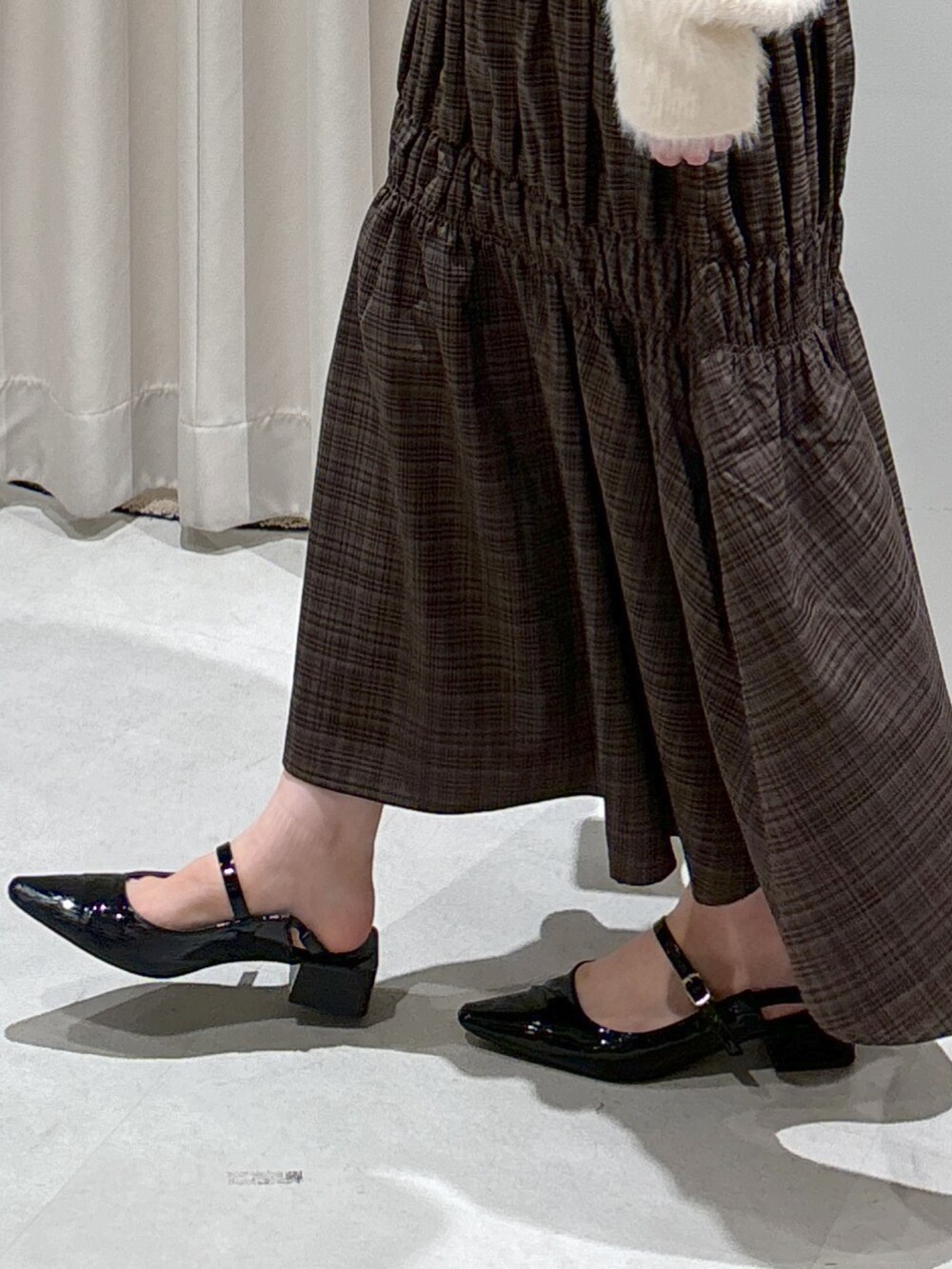 ホワイト系のカーディガン/ボレロ、ブラック系のキャミソール、ブラック系のショルダーバッグを着用したレディースの秋コーディネートの7枚目の写真