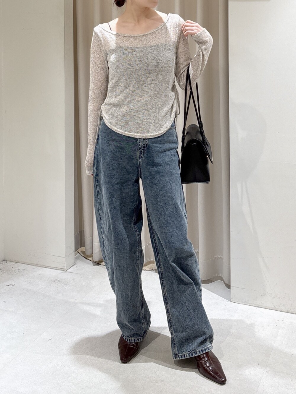 ホワイト系のTシャツ/カットソー、ブラック系のショルダーバッグ、ブルー系のデニムパンツを着用したレディースの冬コーディネートの3枚目の写真