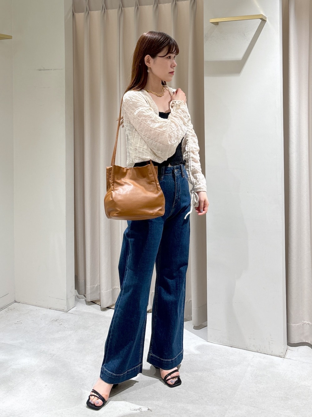 ホワイト系のカーディガン/ボレロ、ブラック系のキャミソール、ブルー系のデニムパンツを着用したレディースの夏コーディネートの3枚目の写真