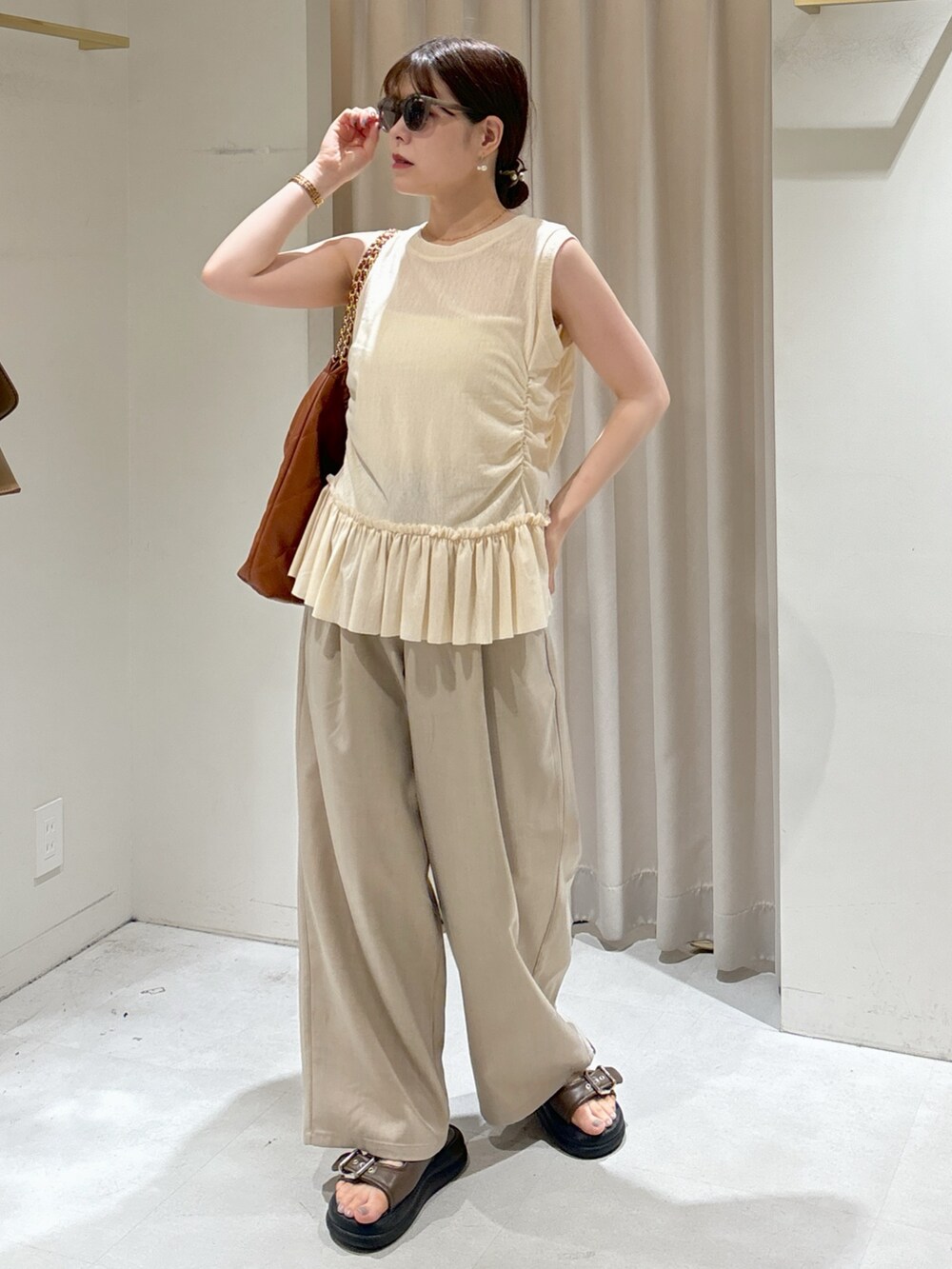 イエロー系のTシャツ/カットソー、ホワイト系のキャミソール、ブラウン系のトートバッグを着用したレディースの夏コーディネートの2枚目の写真