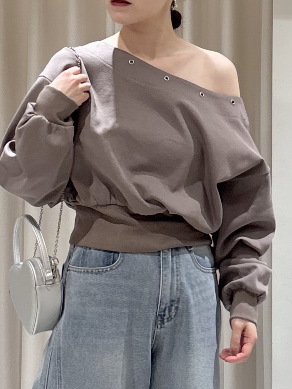 ブラウン系のスウェット、ブルー系のデニムパンツ、シルバー系のショルダーバッグを着用したレディースの冬コーディネートの6枚目の写真