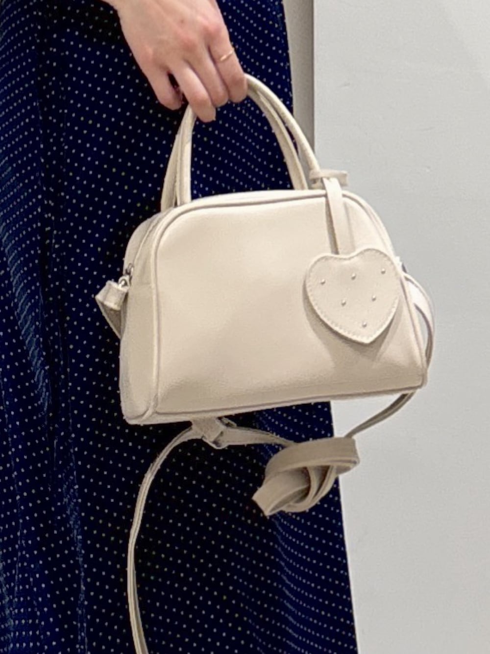 ブルー系のワンピース、ホワイト系のボストンバッグ、ブルー系のデニムパンツを着用したレディースの夏コーディネートの5枚目の写真