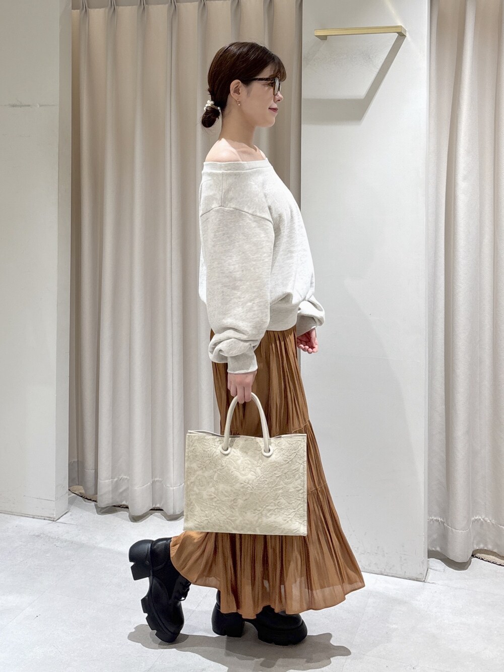 ホワイト系のTシャツ/カットソー、ベージュ系のスカート、ホワイト系のトートバッグを着用したレディースの秋コーディネートの2枚目の写真