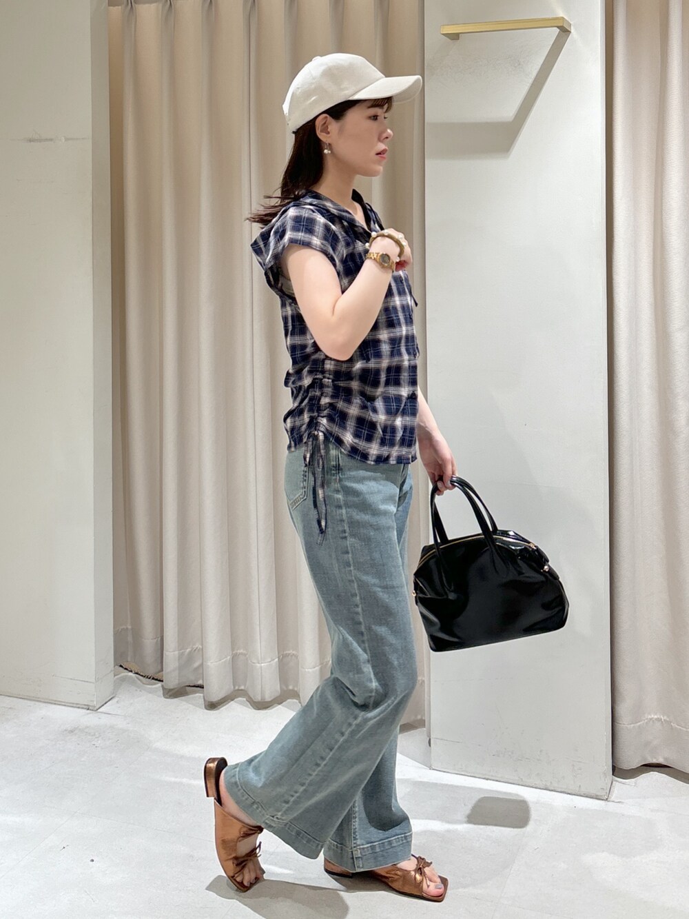 ブルー系のシャツ/ブラウス、ブルー系のデニムパンツ、ブラック系のボストンバッグを着用したレディースの夏コーディネートの4枚目の写真