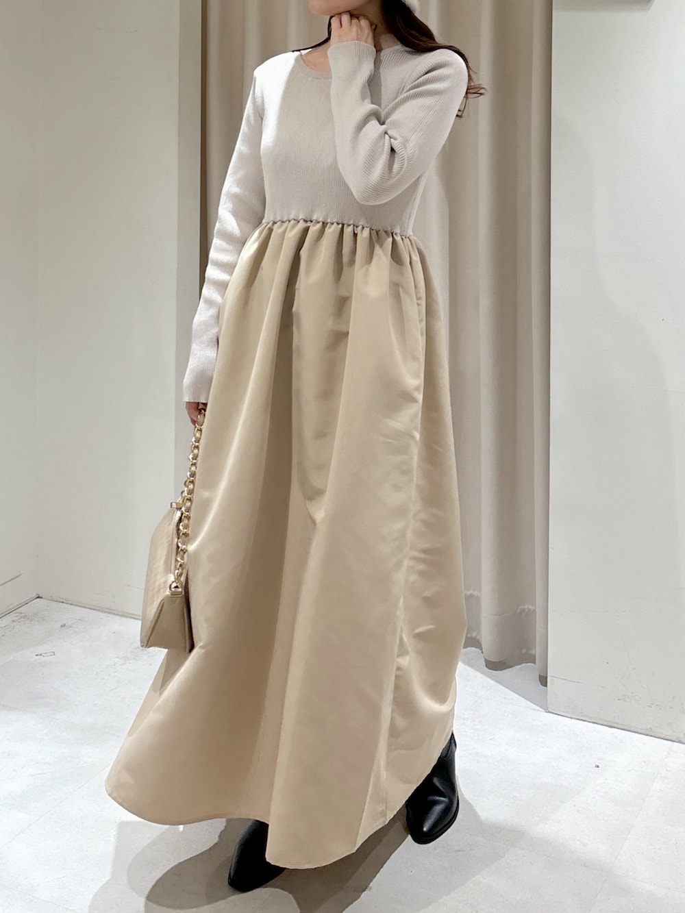 グレー系のTシャツ/カットソー、ベージュ系のトートバッグ、ブラック系のブーツを着用したレディースの冬コーディネートの2枚目の写真