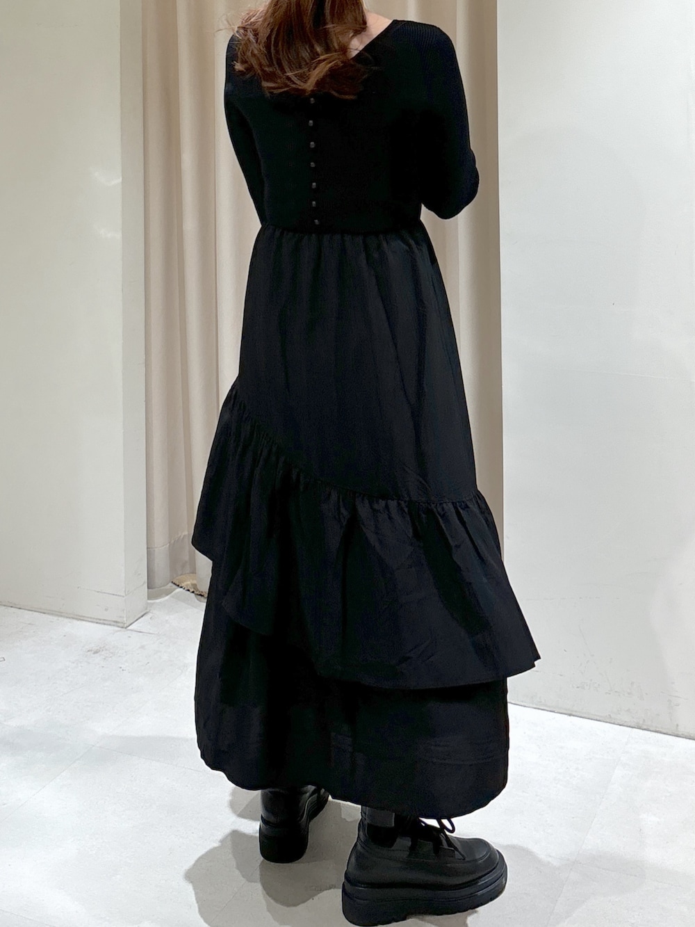 グリーン系のマウンテンパーカー、ブラック系のワンピース、ブラック系のブーツを着用したレディースの冬コーディネートの5枚目の写真