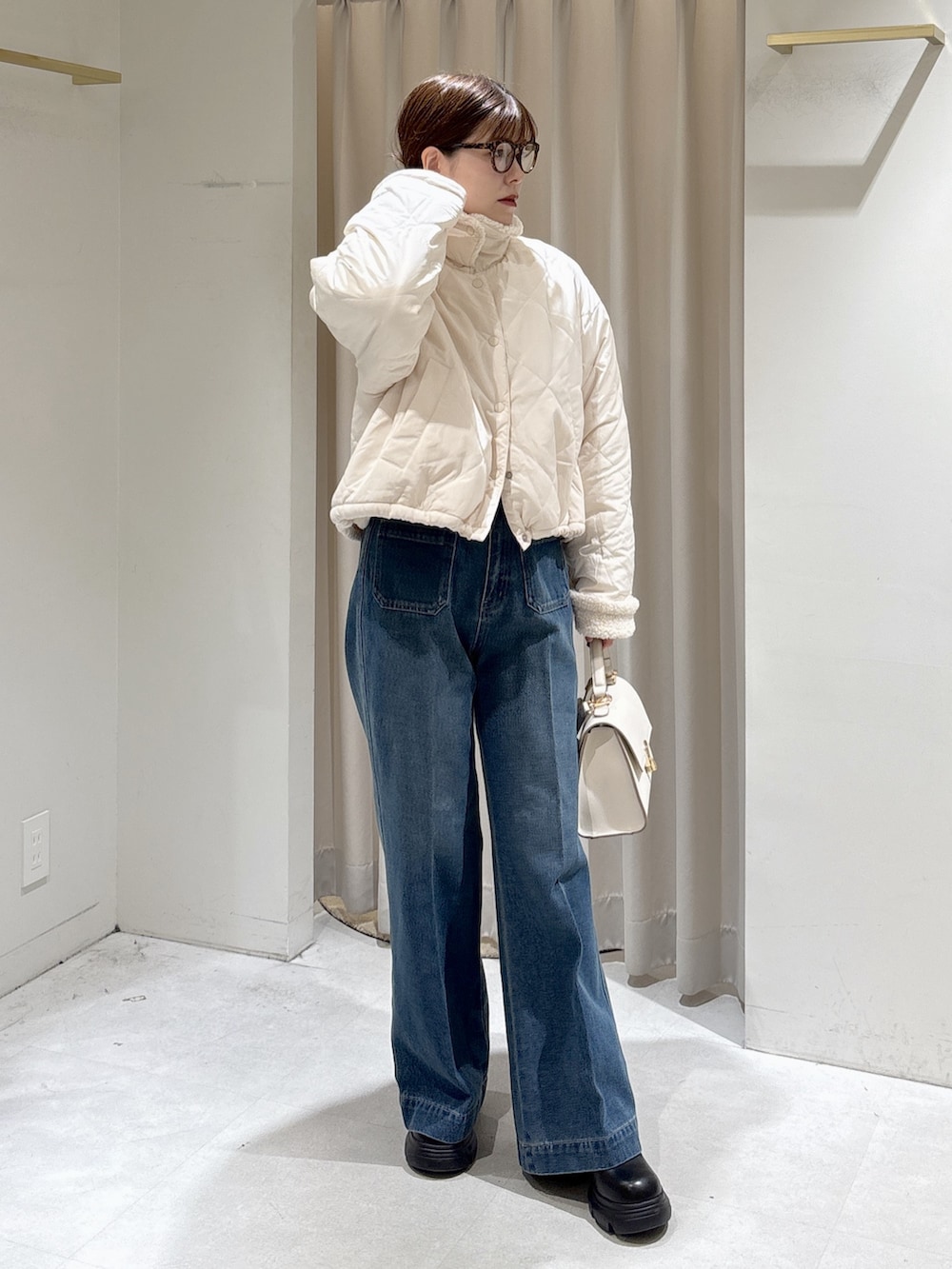 グレー系のニット/セーター、ブルー系のデニムパンツ、ホワイト系のトートバッグを着用したレディースの秋コーディネートの7枚目の写真