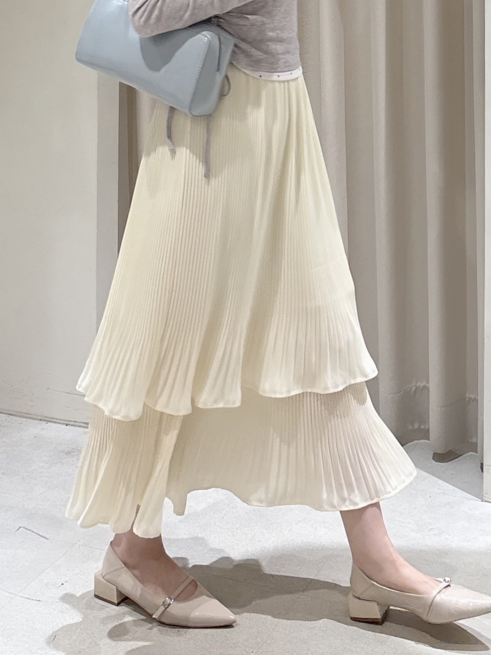 ベージュ系のテーラードジャケット、グレー系のTシャツ/カットソー、ホワイト系のスカートを着用したレディースの春コーディネートの7枚目の写真