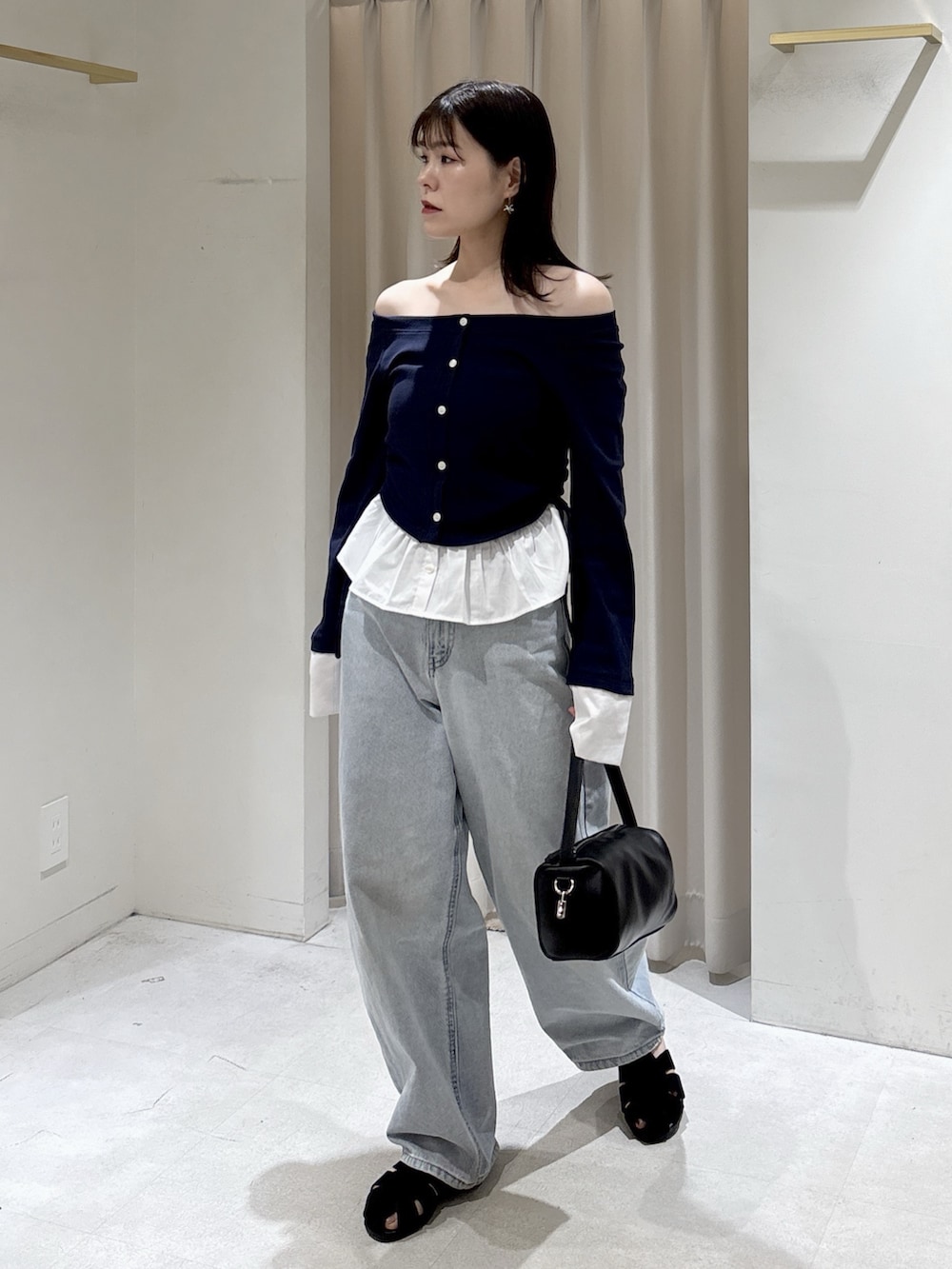 ブルー系のTシャツ/カットソー、ブラック系のハンドバッグ、ブルー系のデニムパンツを着用したレディースの春コーディネートの2枚目の写真