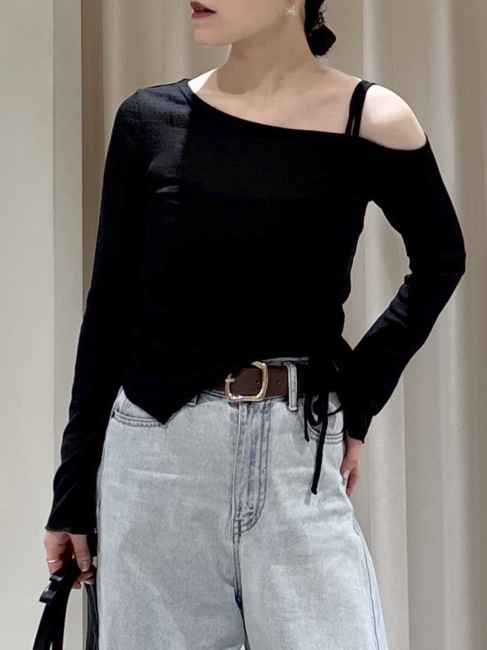 ブラック系のTシャツ/カットソー、ブルー系のデニムパンツ、ブラック系のショルダーバッグを着用したレディースの春コーディネートの3枚目の写真