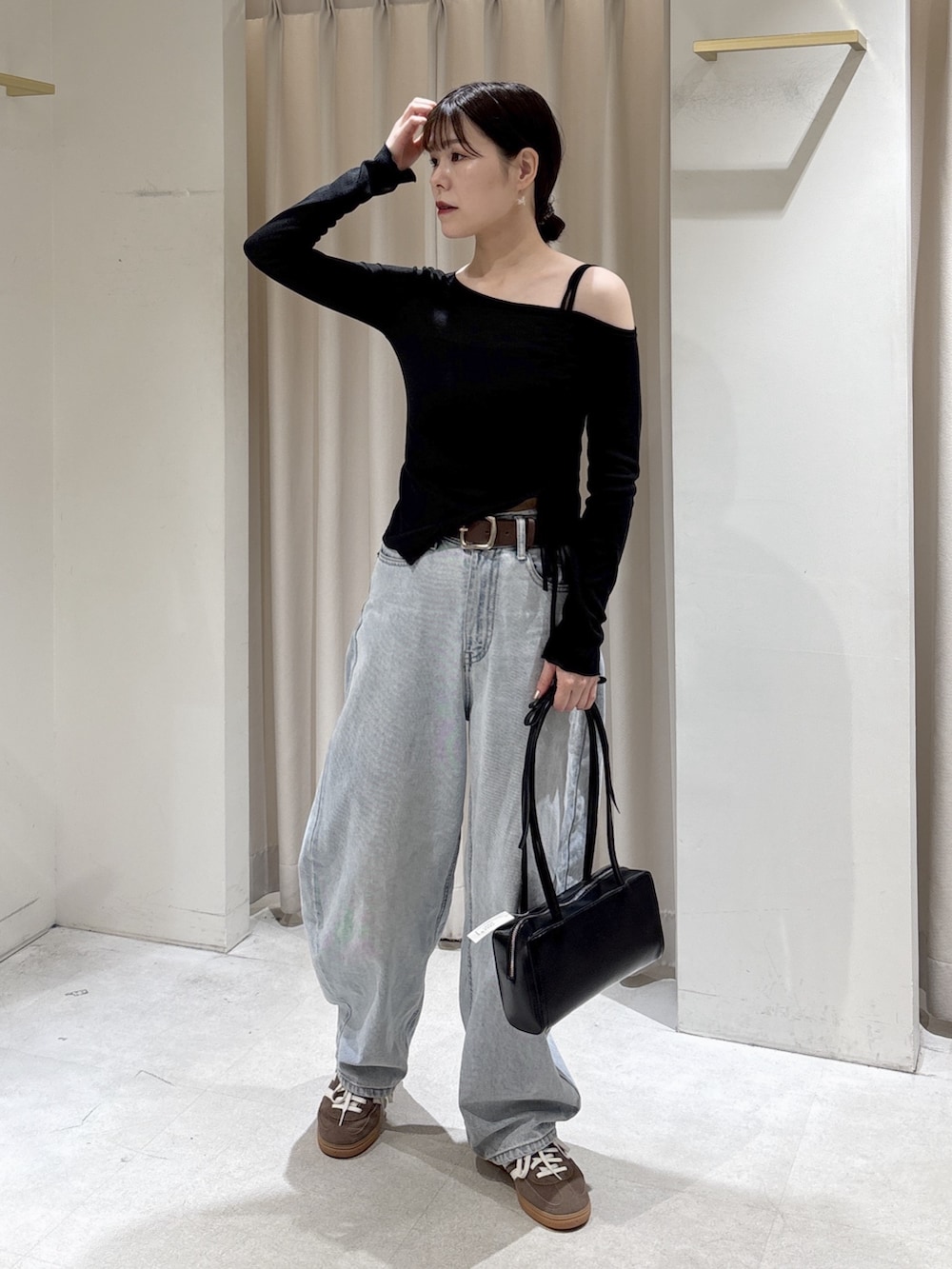 ブラック系のTシャツ/カットソー、ブルー系のデニムパンツ、ブラック系のショルダーバッグを着用したレディースの春コーディネートの2枚目の写真