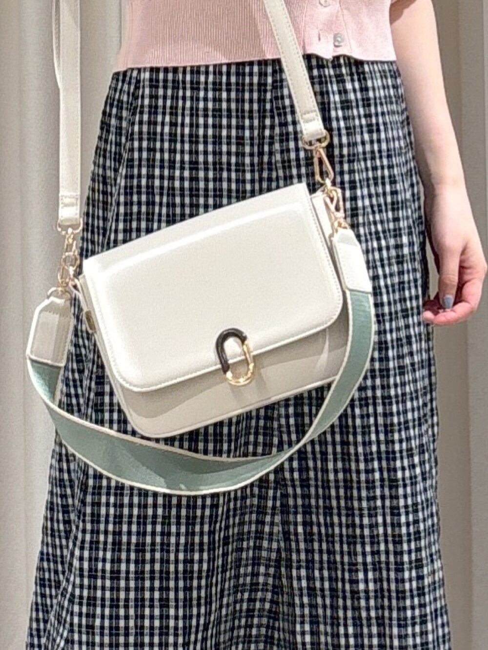 ブラック系のワンピース、ピンク系のカーディガン/ボレロ、ホワイト系のショルダーバッグを着用したレディースの春コーディネートの4枚目の写真