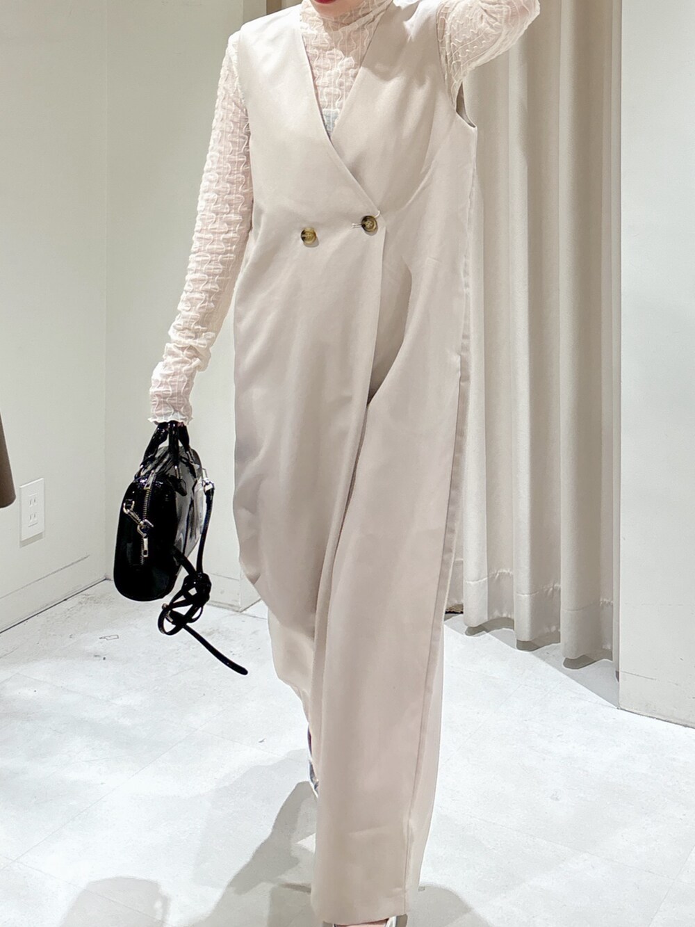 ベージュ系のつなぎ/オールインワン、ホワイト系のTシャツ/カットソー、ブラック系のショルダーバッグを着用したレディースの冬コーディネートの4枚目の写真