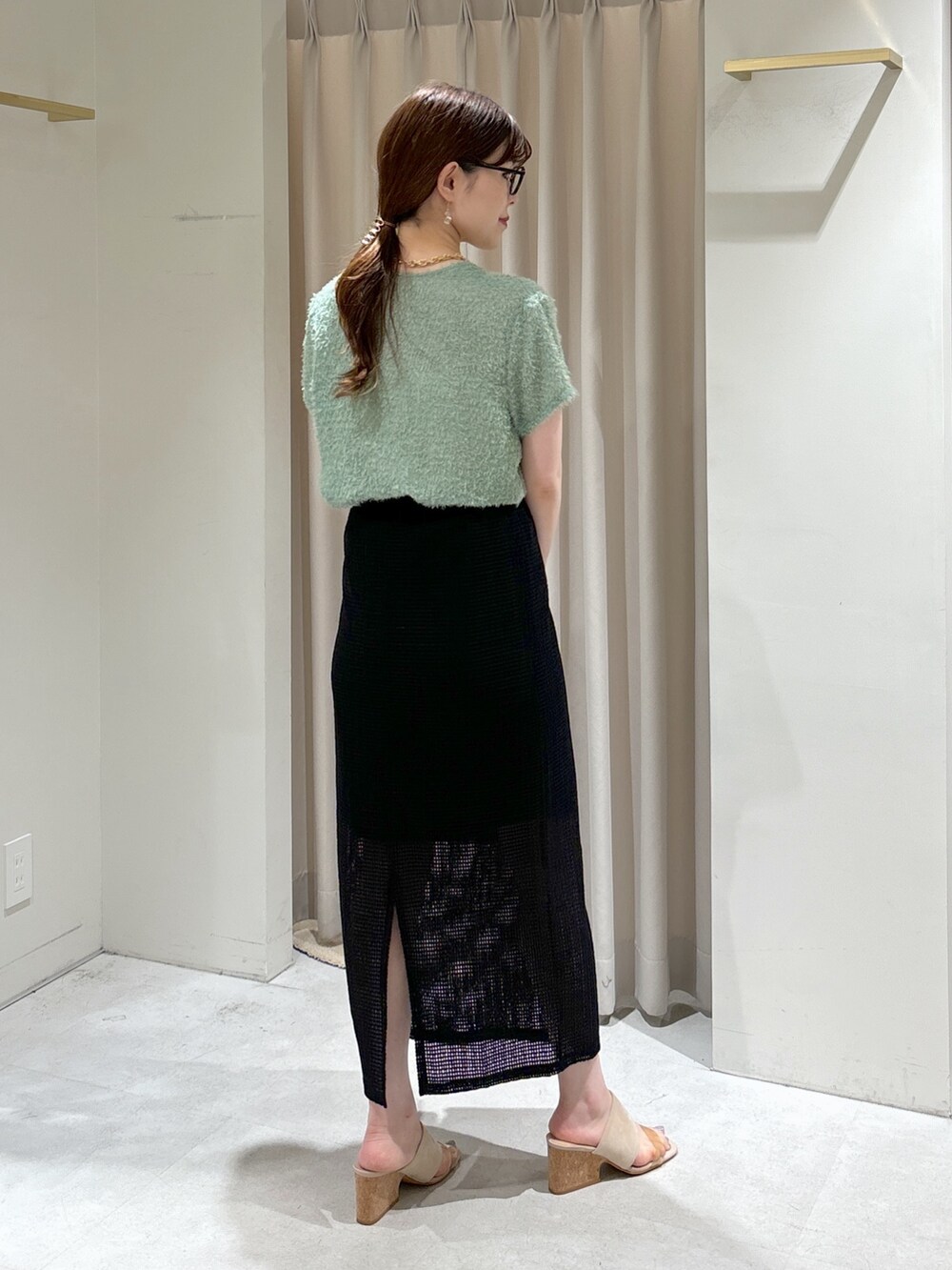 ブラック系のスカート、グレー系のサンダル、ホワイト系のハンドバッグを着用したレディースの夏コーディネートの4枚目の写真