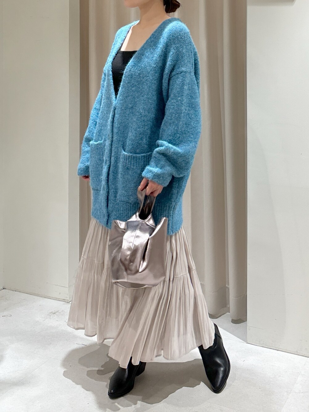 ブルー系のカーディガン/ボレロ、ブラック系のキャミソール、ホワイト系のスカートを着用したレディースの秋コーディネートの2枚目の写真