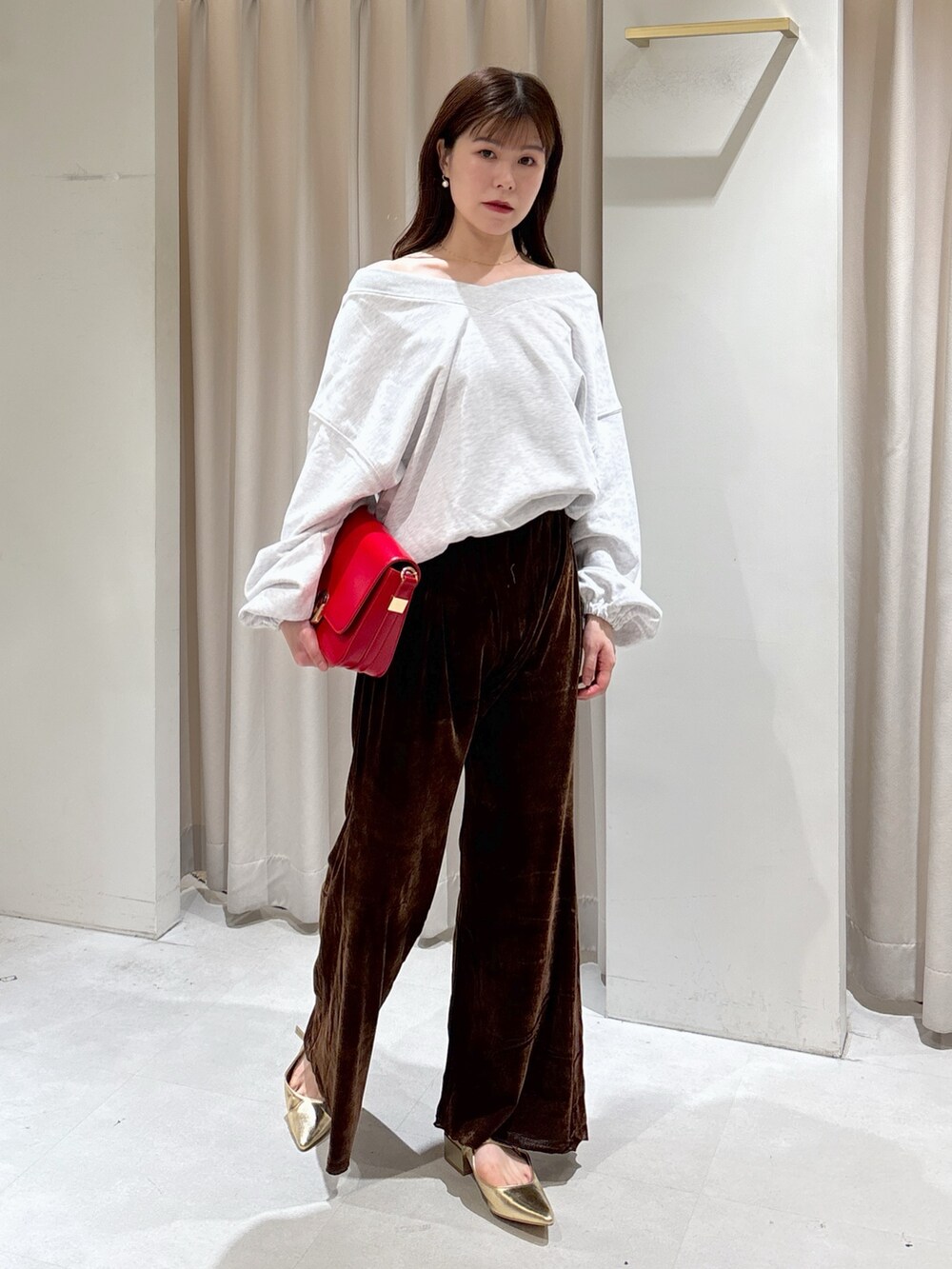 ホワイト系のスウェット、レッド系のハンドバッグ、ブラウン系のその他パンツを着用したレディースの秋コーディネートの2枚目の写真