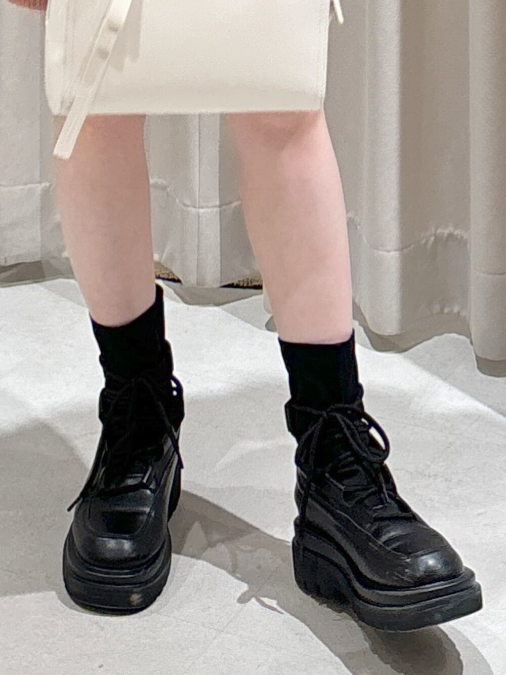 ピンク系のワンピース、ホワイト系のショルダーバッグ、ブラック系のブーツを着用したレディースの冬コーディネートの6枚目の写真