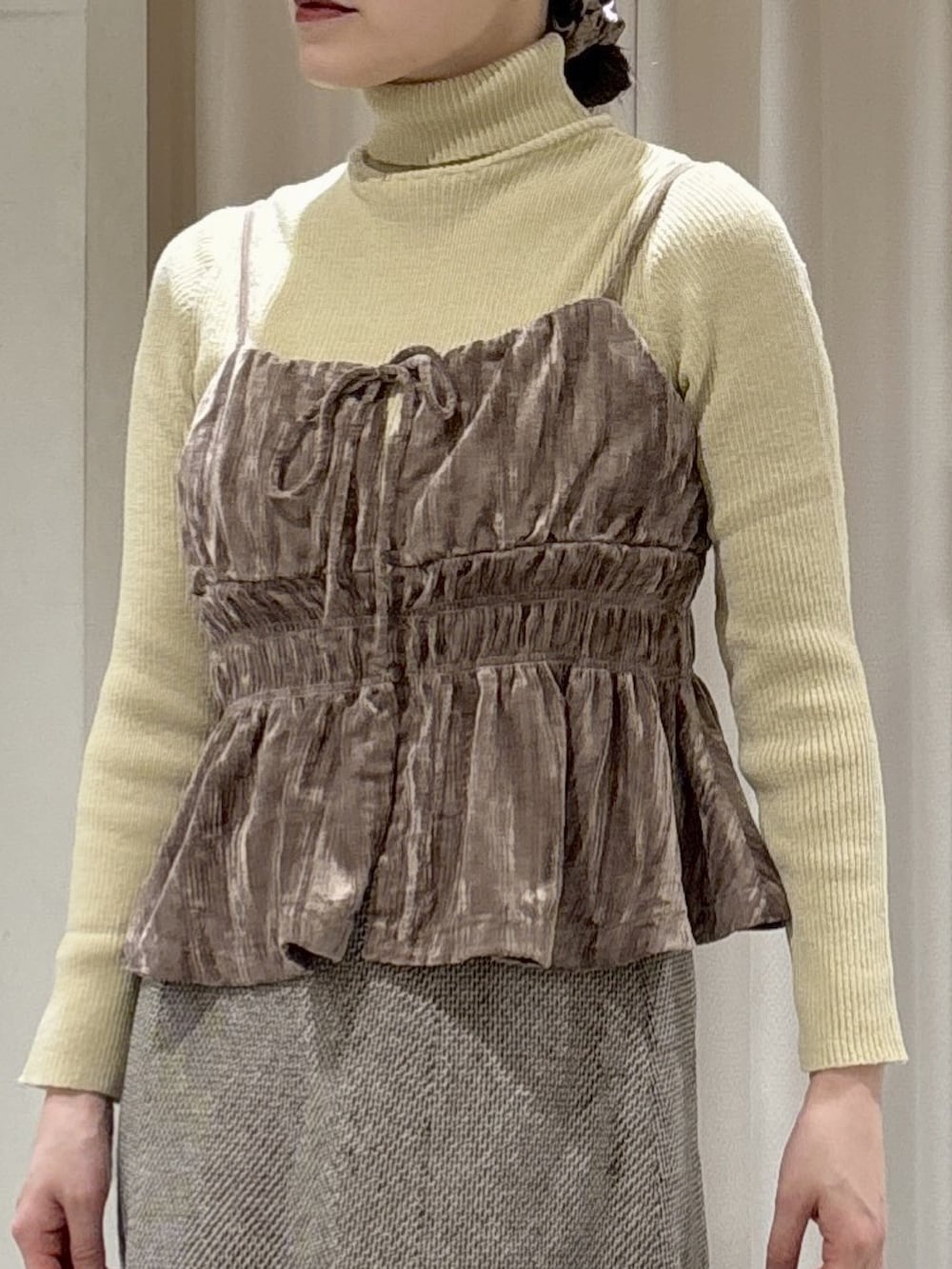 ベージュ系のシャツ/ブラウス、イエロー系のニット/セーター、ブラウン系のスカートを着用したレディースの冬コーディネートの3枚目の写真