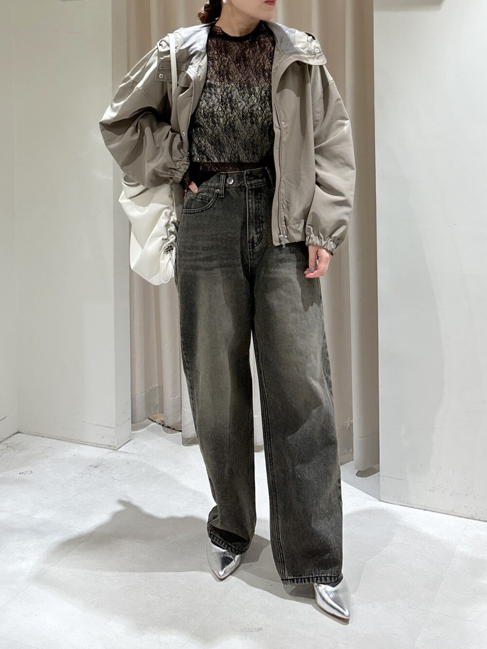 グリーン系のマウンテンパーカー、ブラック系のTシャツ/カットソー、ホワイト系のキャミソールを着用したレディースの冬コーディネートの2枚目の写真