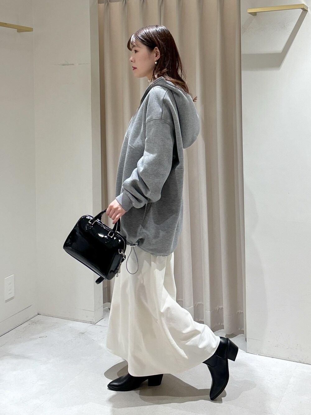ホワイト系のTシャツ/カットソー、ブラック系のショルダーバッグ、ホワイト系のスカートを着用したレディースの冬コーディネートの4枚目の写真