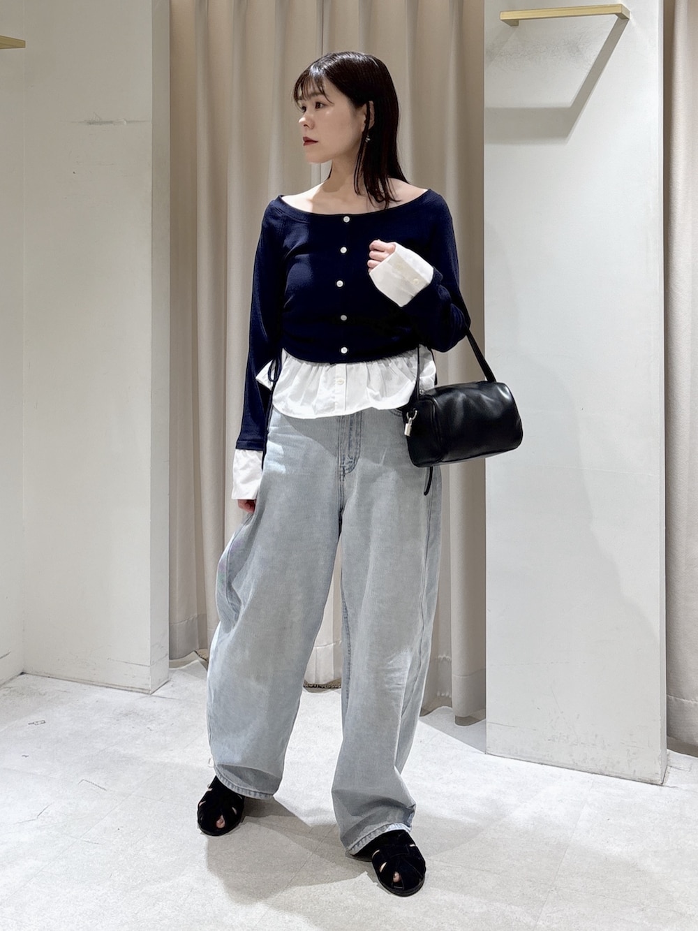 ブルー系のTシャツ/カットソー、ブラック系のハンドバッグ、ブルー系のデニムパンツを着用したレディースの春コーディネートの4枚目の写真