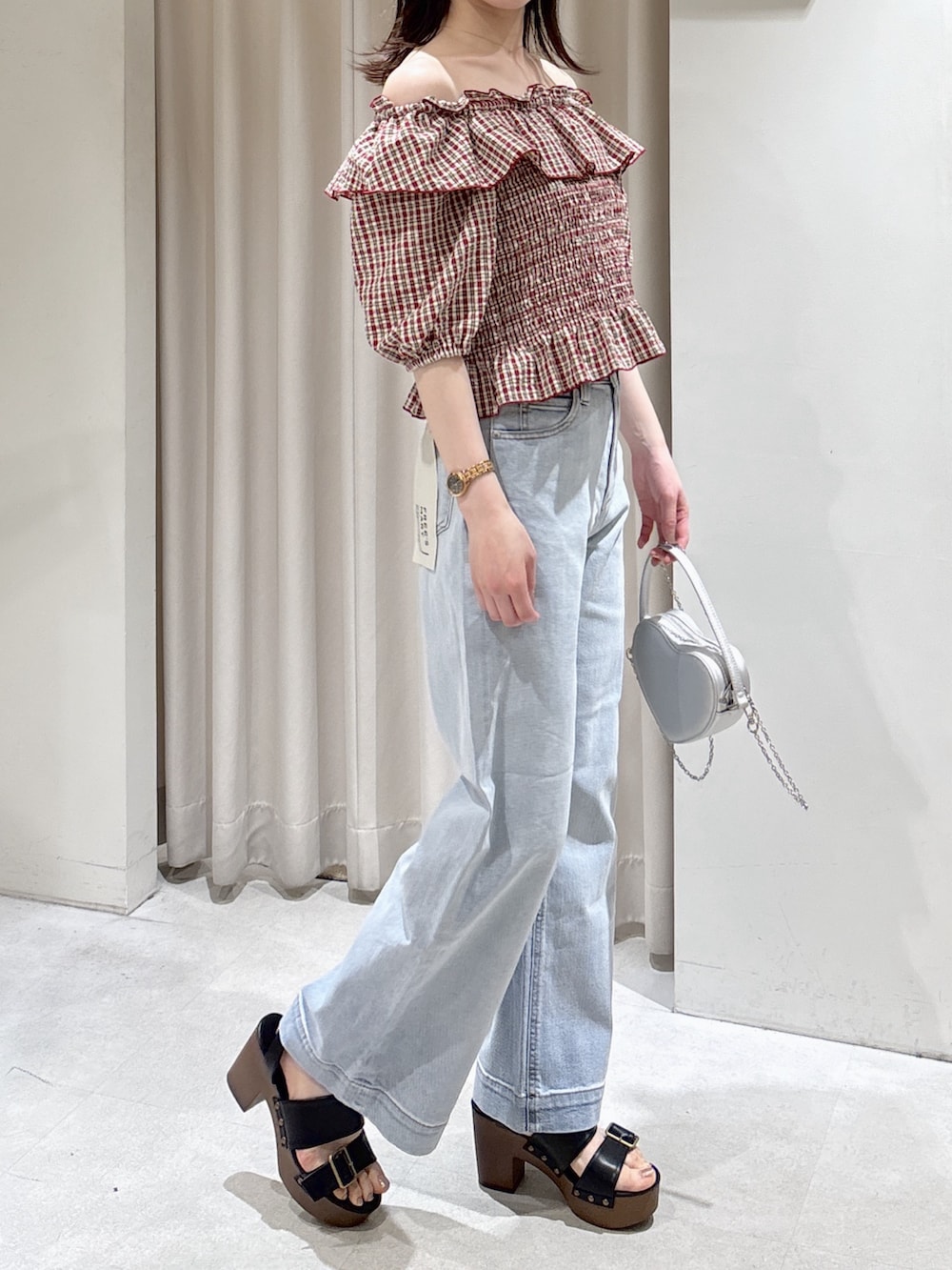 レッド系のシャツ/ブラウス、ブルー系のデニムパンツ、シルバー系のショルダーバッグを着用したレディースの春コーディネートの7枚目の写真