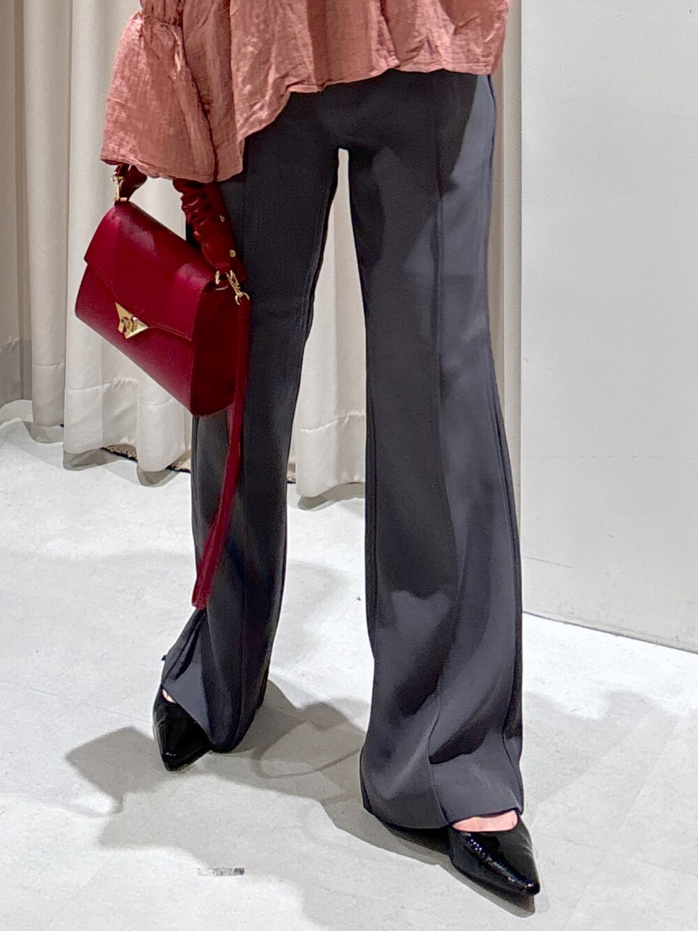 ブラック系のシャツ/ブラウス、レッド系のショルダーバッグ、グレー系のスラックスを着用したレディースの秋コーディネートの5枚目の写真