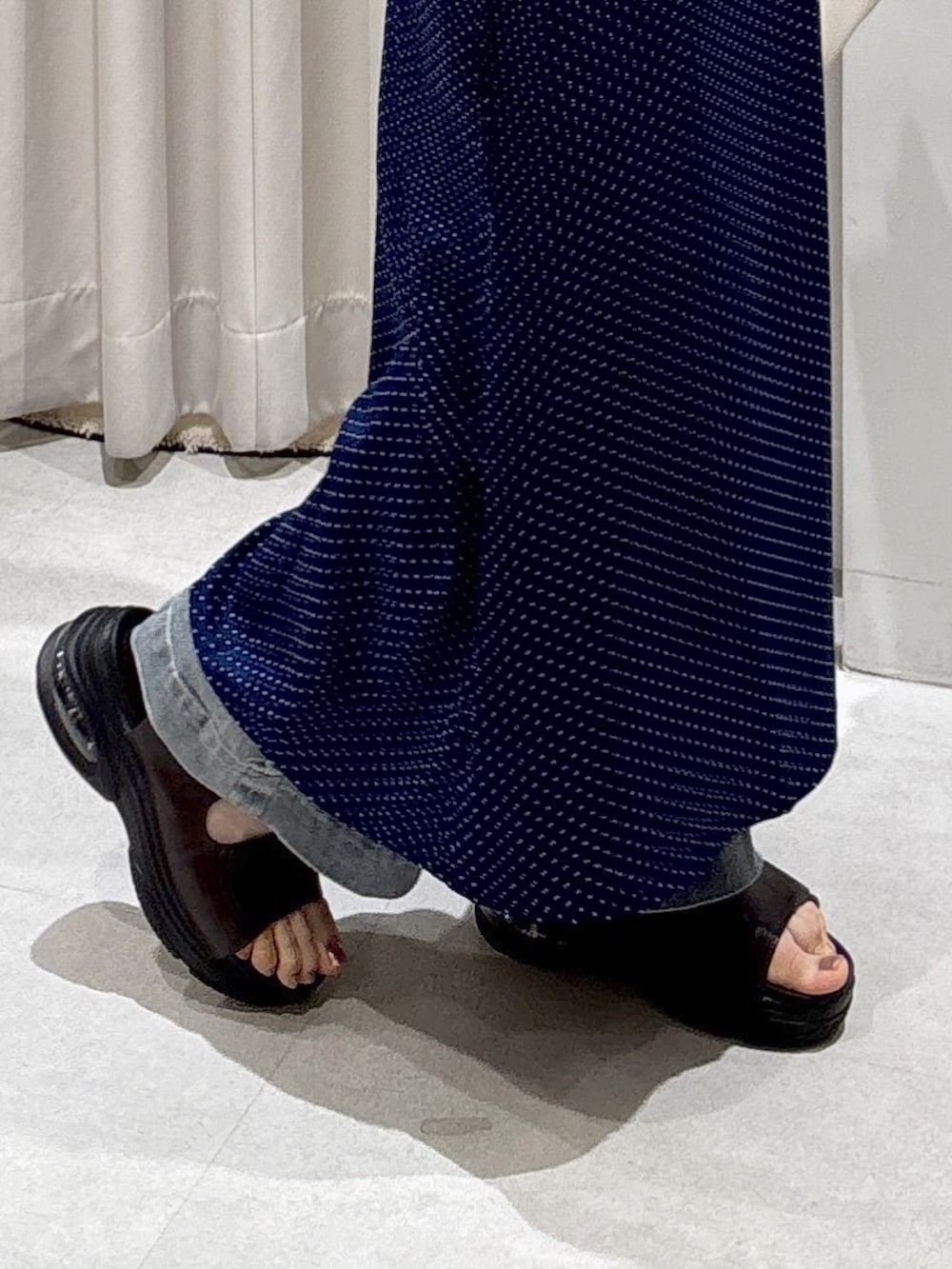 ブルー系のワンピース、ホワイト系のボストンバッグ、ブルー系のデニムパンツを着用したレディースの夏コーディネートの4枚目の写真